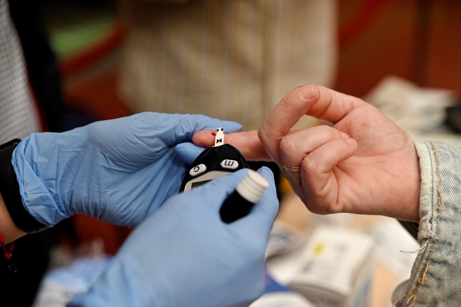 Un sanitario realiza la prueba para medir la glucemia a una persona.