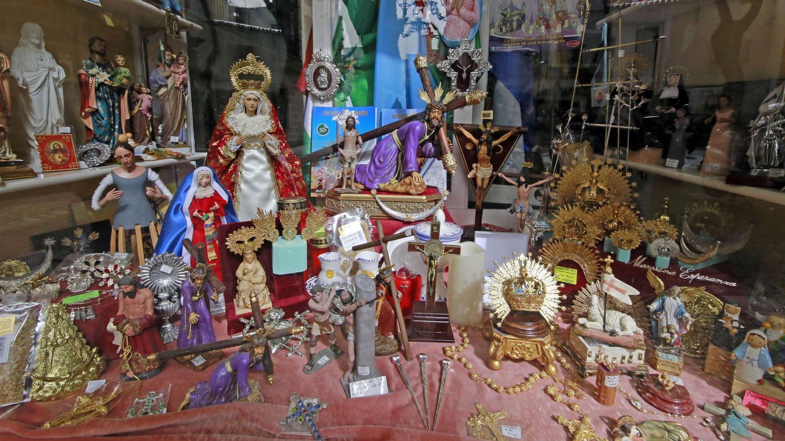 Numerosas miniaturas cofrades dispuestas en la tienda.