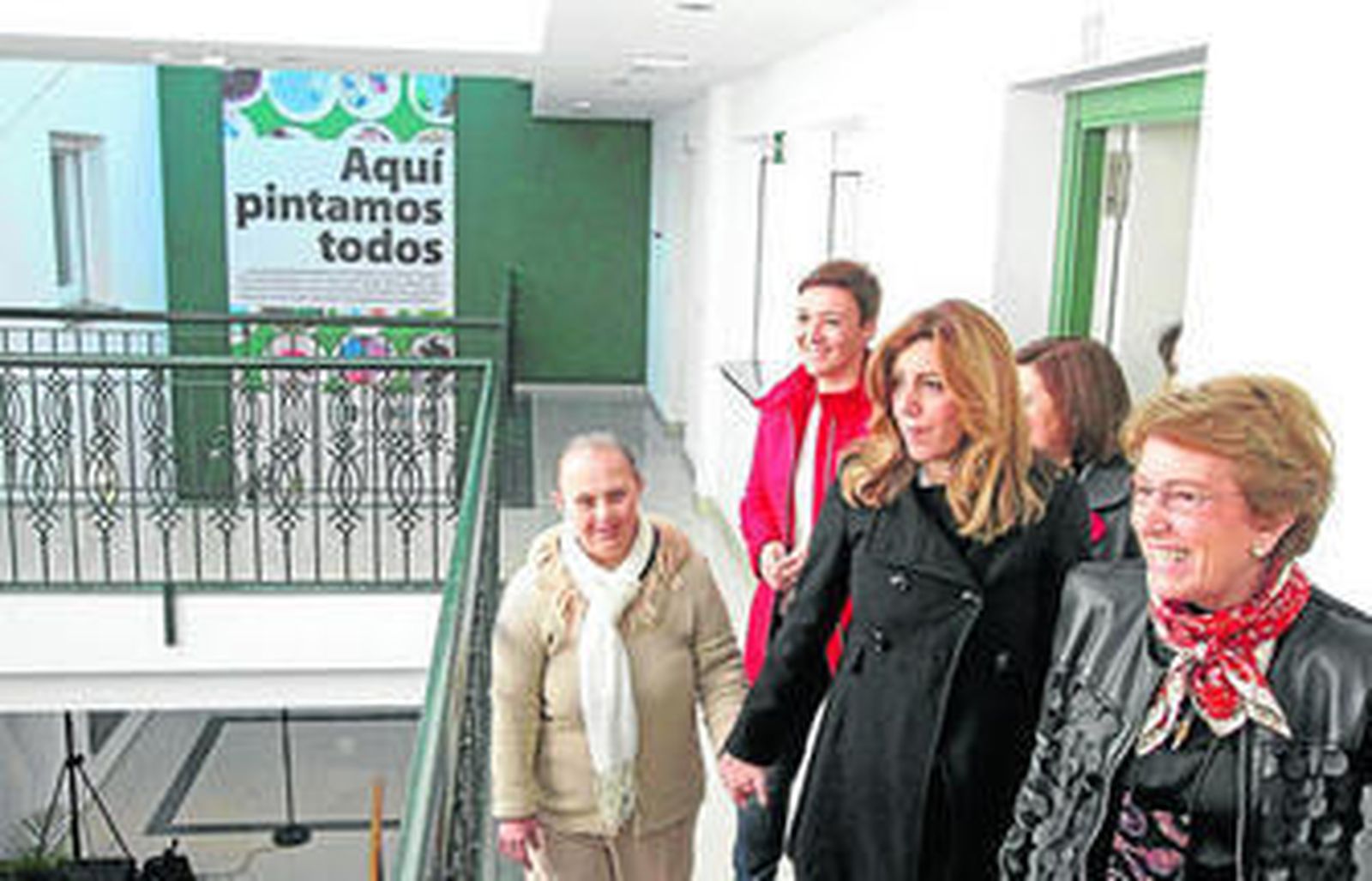 Susana Díaz conoce las instalaciones de Asansull de la mano de una usuaria y acompañada por María Luisa Escribano, presidenta de la entidad.