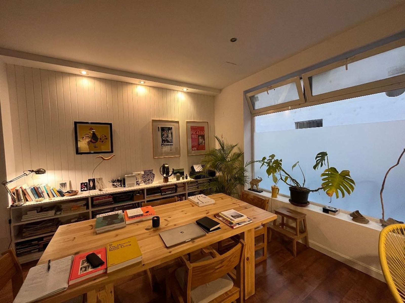 Zona de trabajo con una mesa de pino diseñada por sus propietarios y unas sillas de los 60.