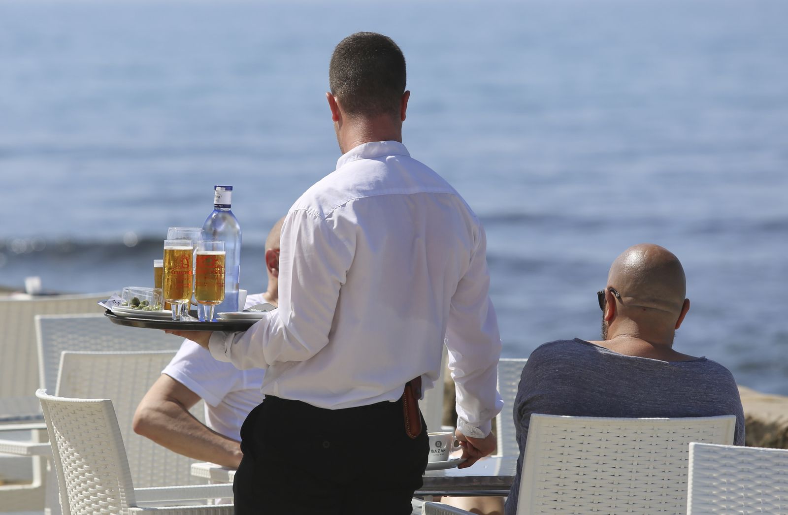 Un camarero atiende una mesa en un establecimiento hostelero de Málaga capital.