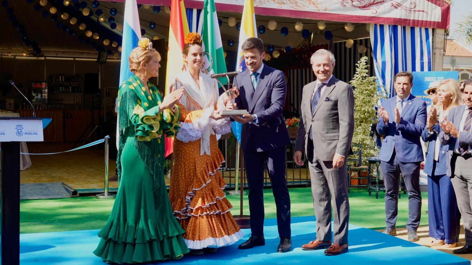 La alcaldesa de Palos de la Frontera, Milagros Romero, recibe el cerrojo de manos del alcalde de Aljaraque, Adrián Cano.