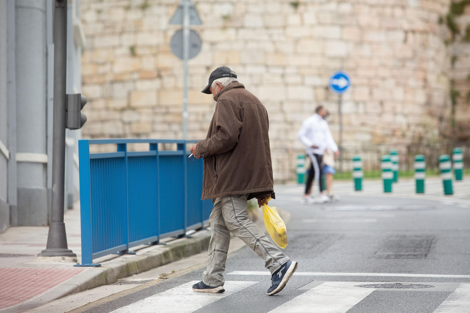 Una persona fuma por la calle en el primer día de restricciones en Galicia.
