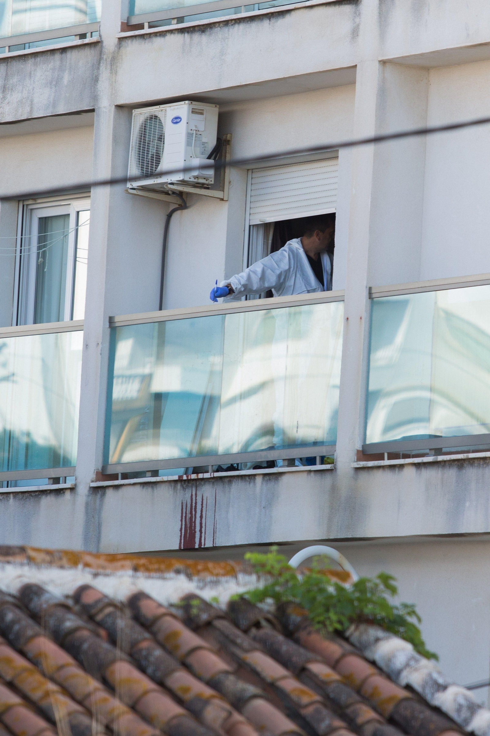 Un agente de la Policía Científica toma posibles huellas en el lugar.