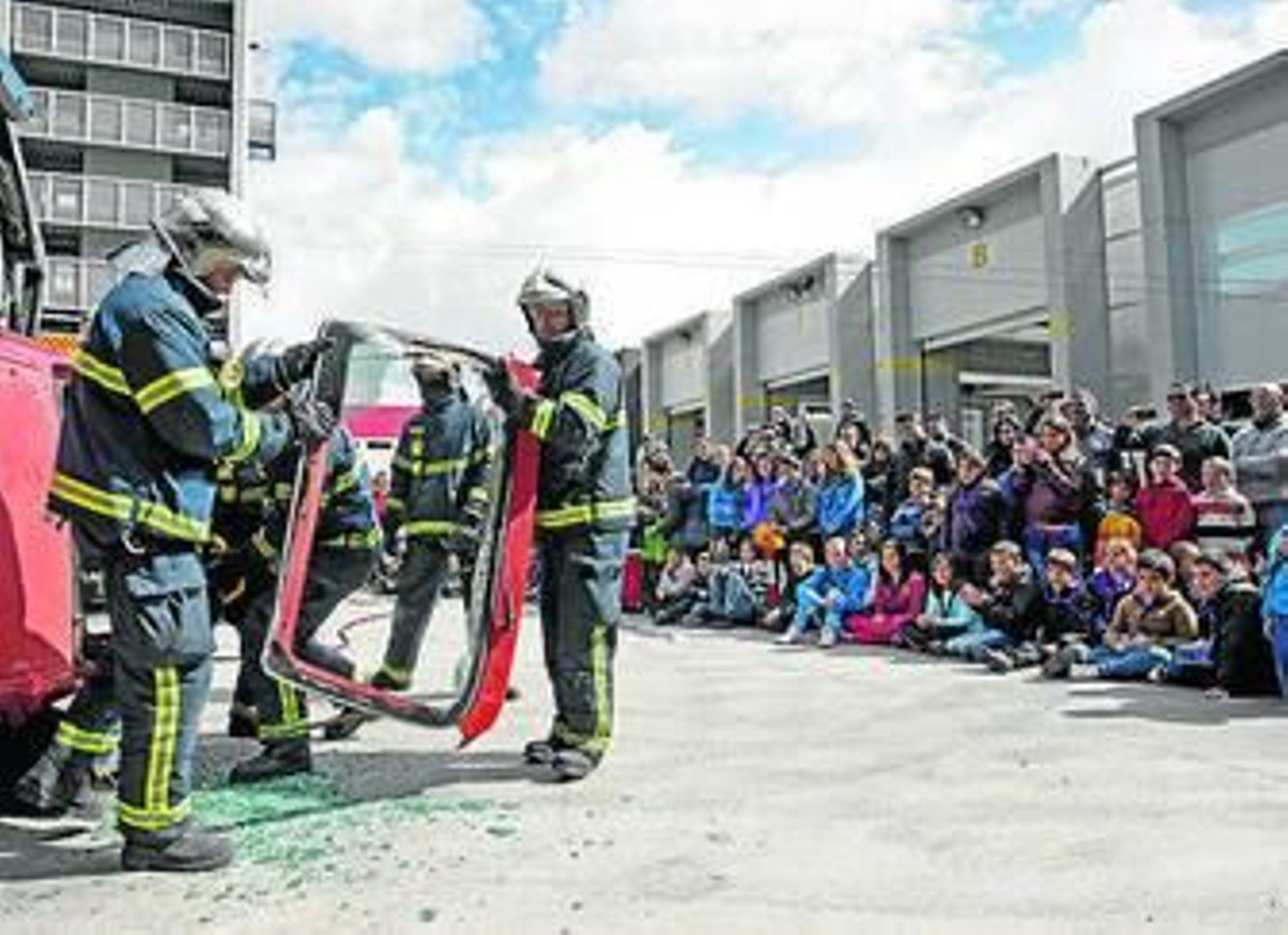 1. Un nutrido número de ciudadanos se desplazó hasta el Parque de Bomberos donde pudo observar una práctica de rescate de altura en camilla simulando un incendio en un edificio. 2. En la imagen vemos a un pequeño que se desplazó hasta el Parque vestido de bombero. 3. Momento de l rescate de una víctima de un accidente de coche. 4. Los efectivos del Parque mostraban el material y respondían a las preguntas de los pequeño.  5. Un chico disfruta al volante de uno de los vehículos del Parque.
