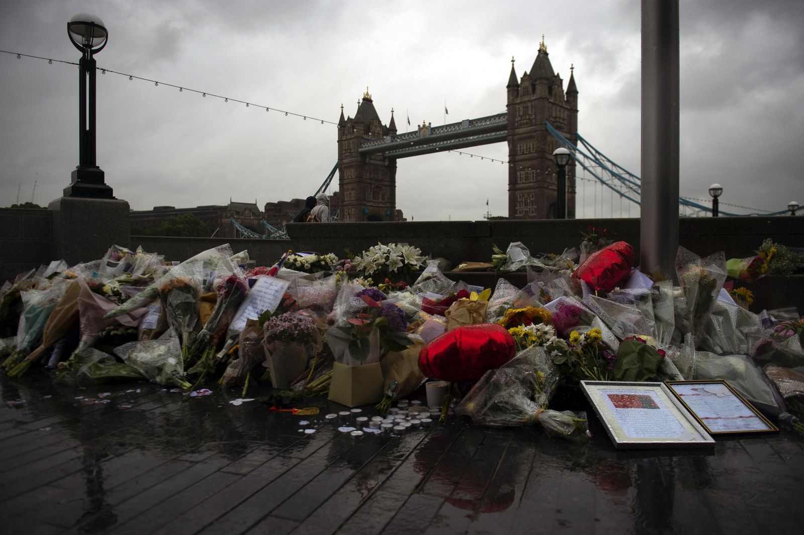 Varios ramos de flores, velas y mensajes dejados en memoria de las víctimas del atentado del Puente de Londres.