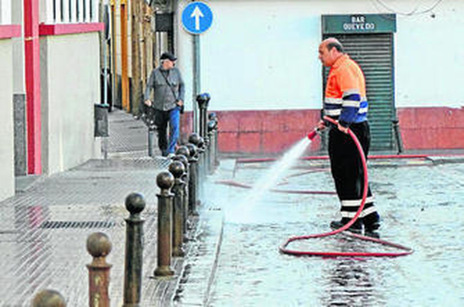 Un operario de limpieza baldeando una de las calles del centro este fin de semana.