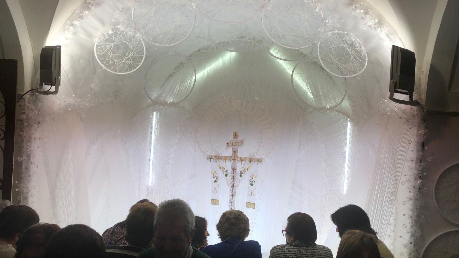 Varias personas contemplan una de las Cruces decoradas en Añora