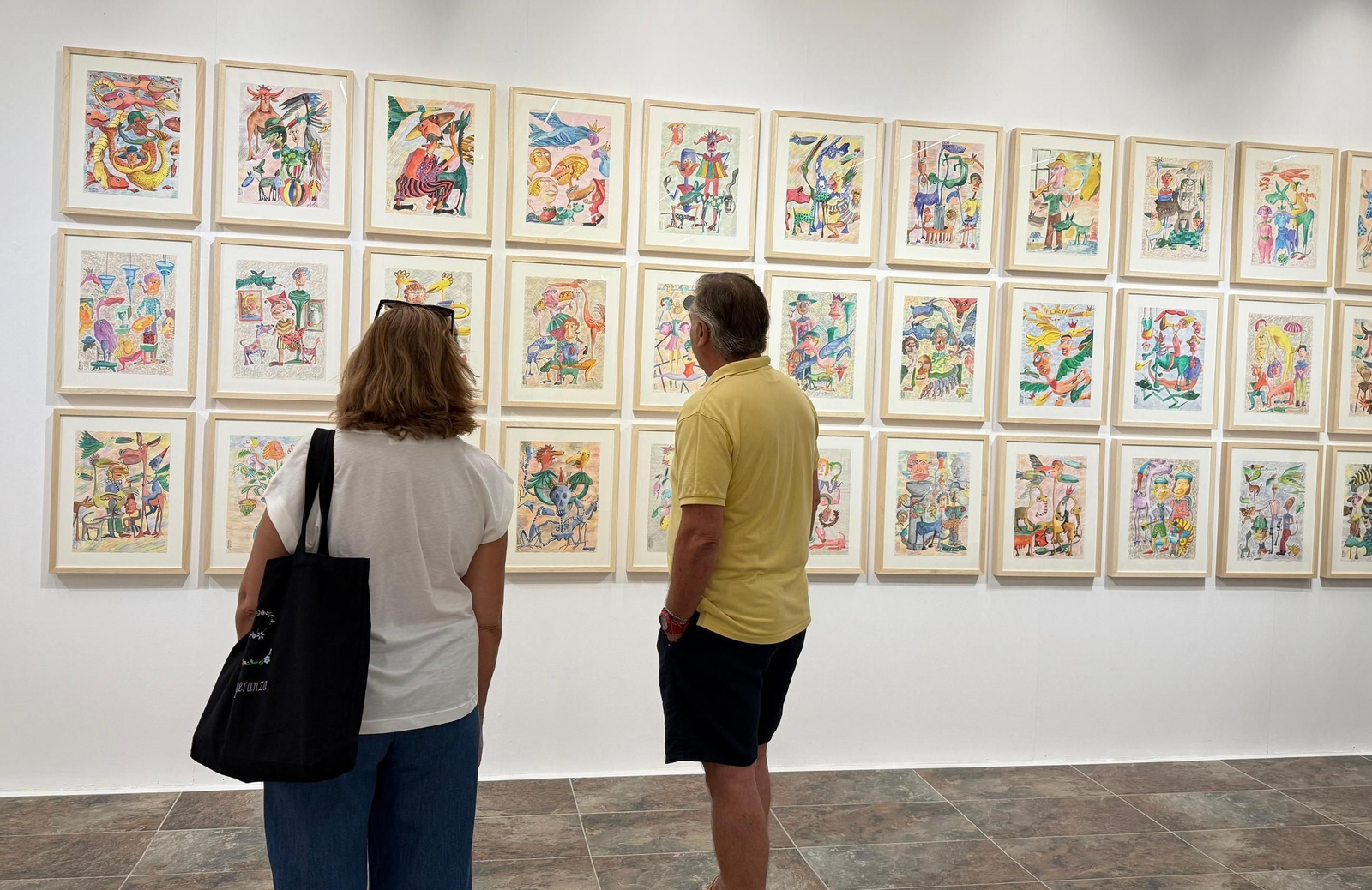 Dos personas observando las obras de la exposición.