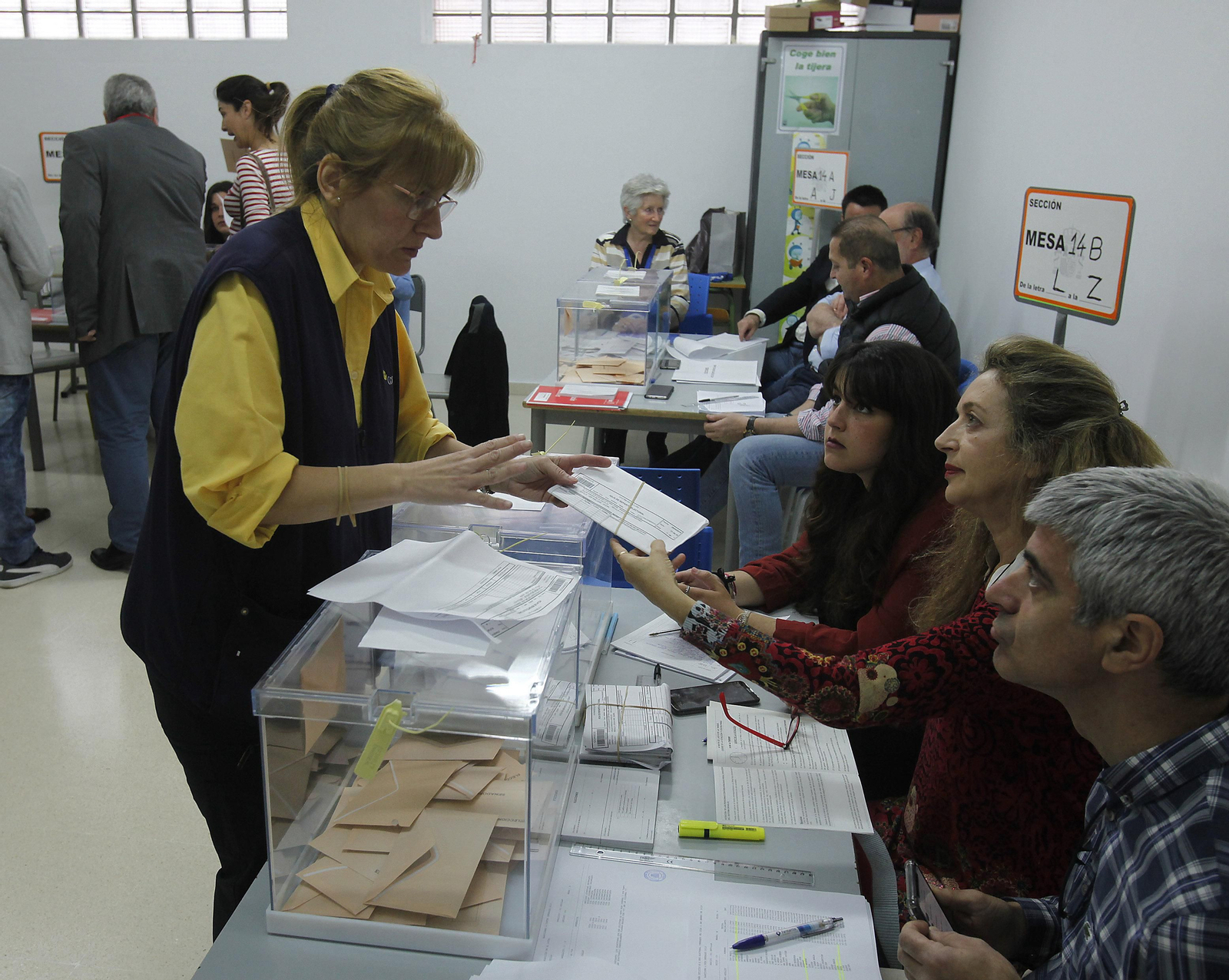 Una empleada de Correos entrega los votos recibidos por vía postal en una mesa de la capital sevillana.