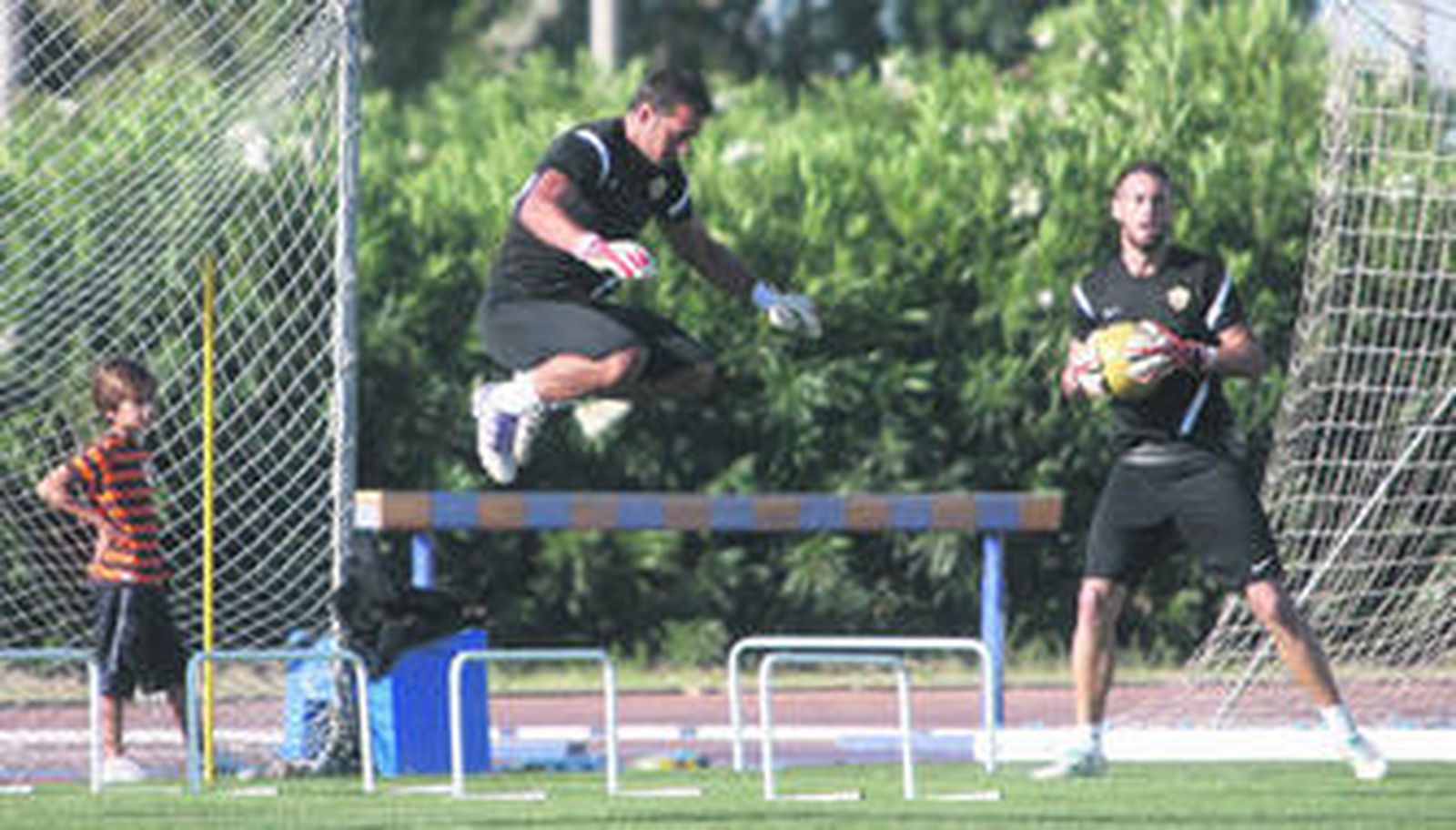 Esteban realiza un ejercicio de salto ante la atenta mirada de uno de sus hijos y de Diego García.