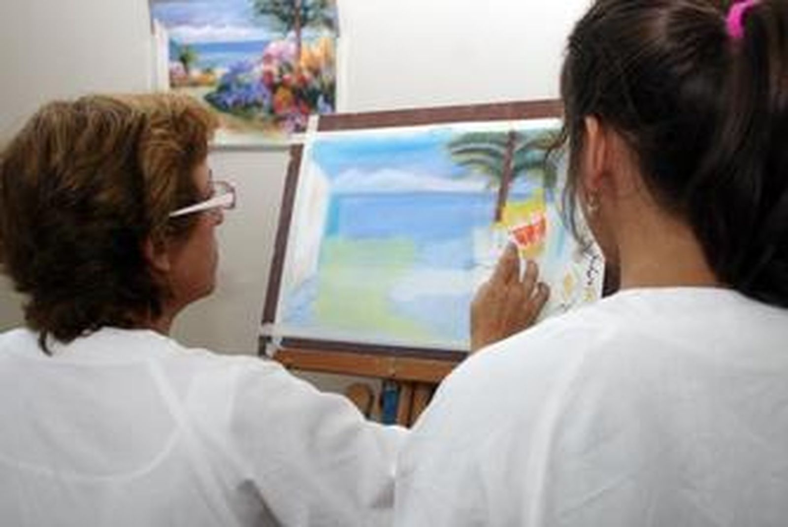 A la izquierda Charo, madre de una joven con epilepsia, dando un taller semananal de manualidades en Apice a chicos con la misma patología.