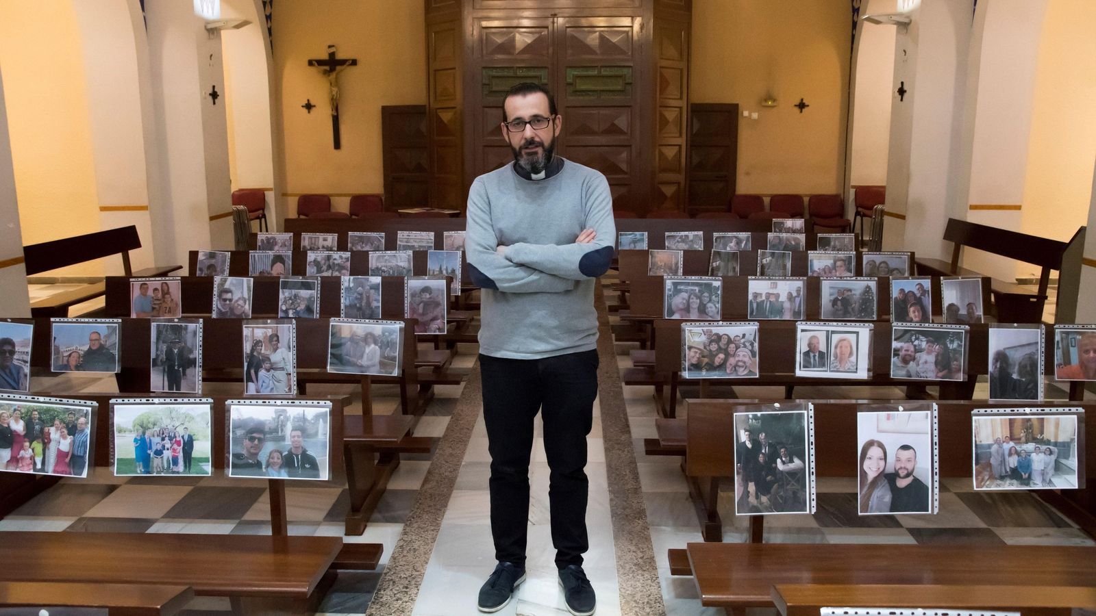 El párroco de Regiones, Antonio Salvador, celebra la misa con los retratos de sus feligreses.