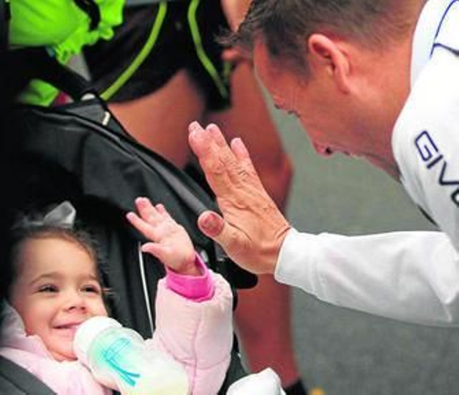 Una niña sonríe a su padre tras correr éste la prueba.