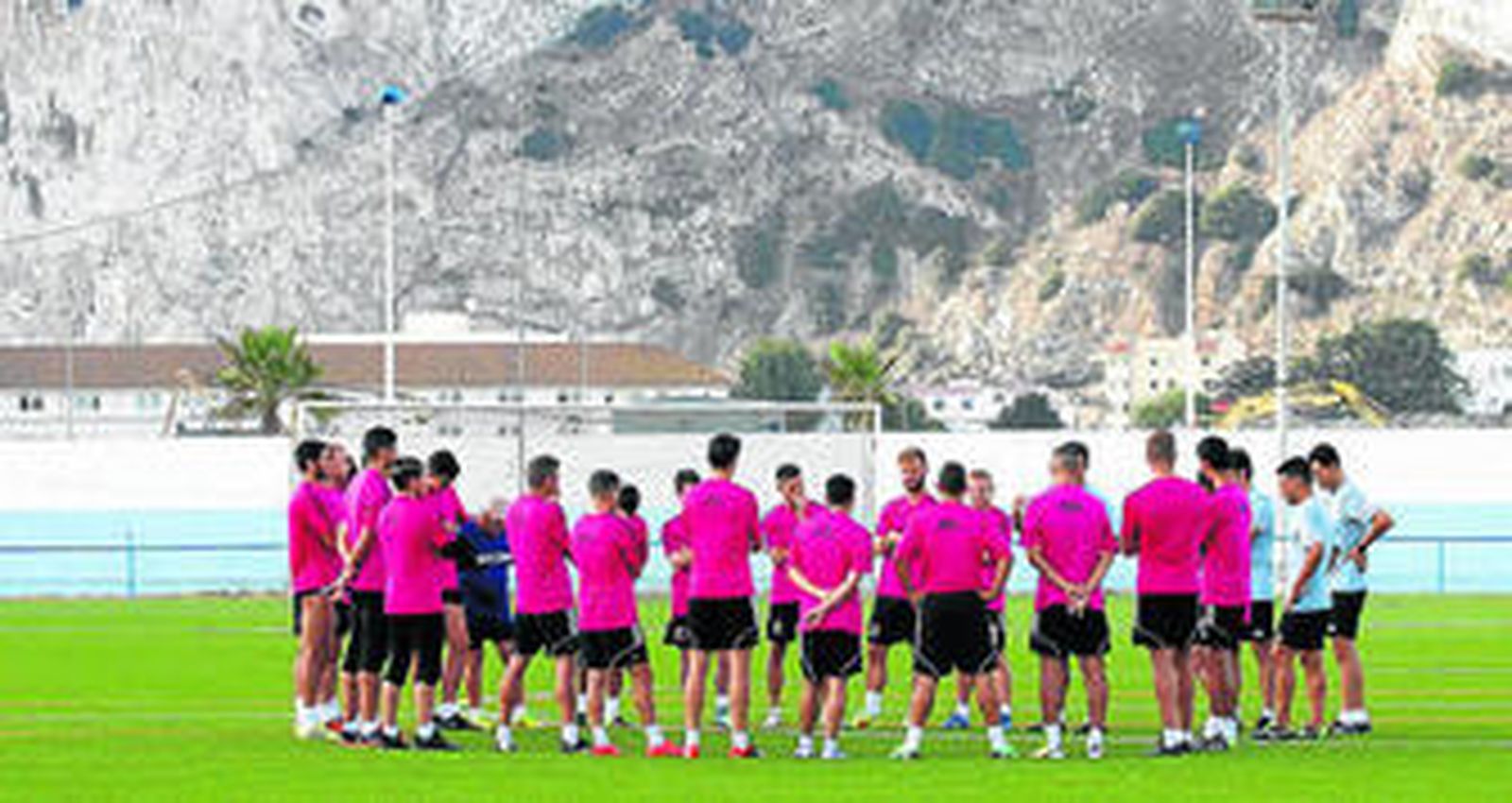 Manolo Ruiz conversa con sus jugadores en uno de los campos de césped sintético de la Ciudad Deportiva de La Línea, ayer.