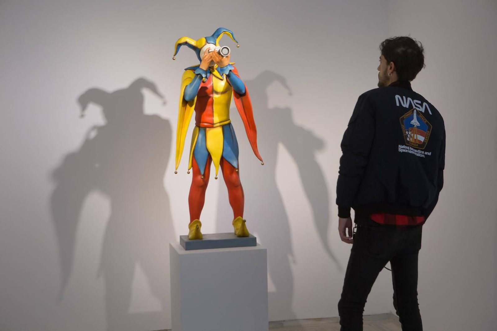 Uno de los visitantes observa uno de los 'joker' de Chema Cobo.