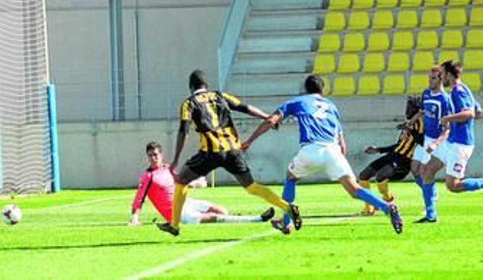 El sanroquista Boateng supera al meta melillense Munir para marcar el tercero de la cuenta de los aurinegros. El sanroquista Boateng supera al meta melillense Munir para marcar el tercero de la cuenta de los aurinegros.