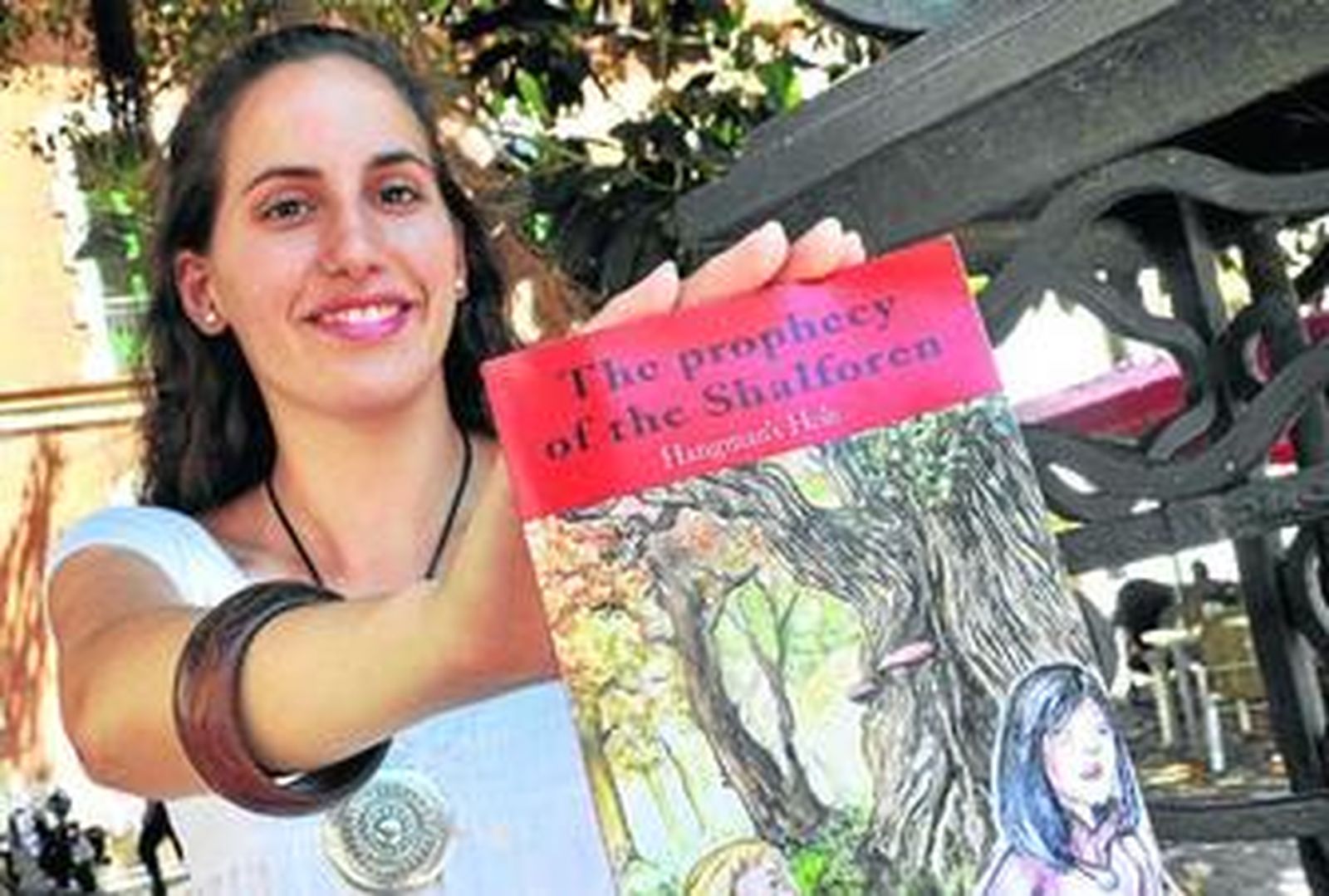 Marta posa con su libro en primer término, días atrás en la Alameda del Banco.