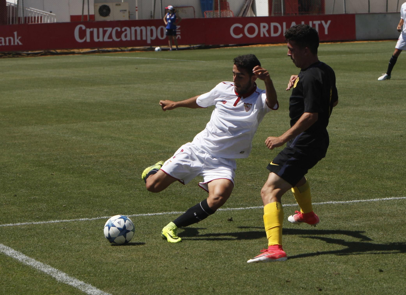 Un jugador del Sevilla juvenil despeja una pelota.