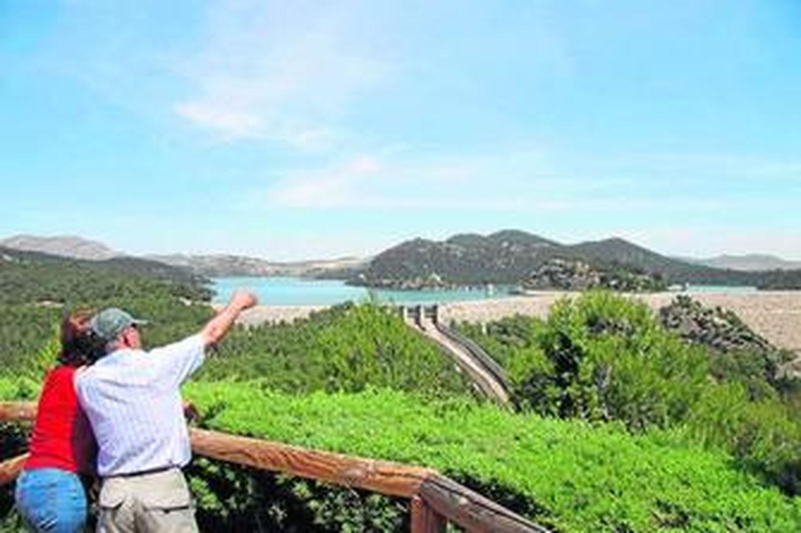 Dos turistas contemplan la presa del pantano del Guadalhorce.
