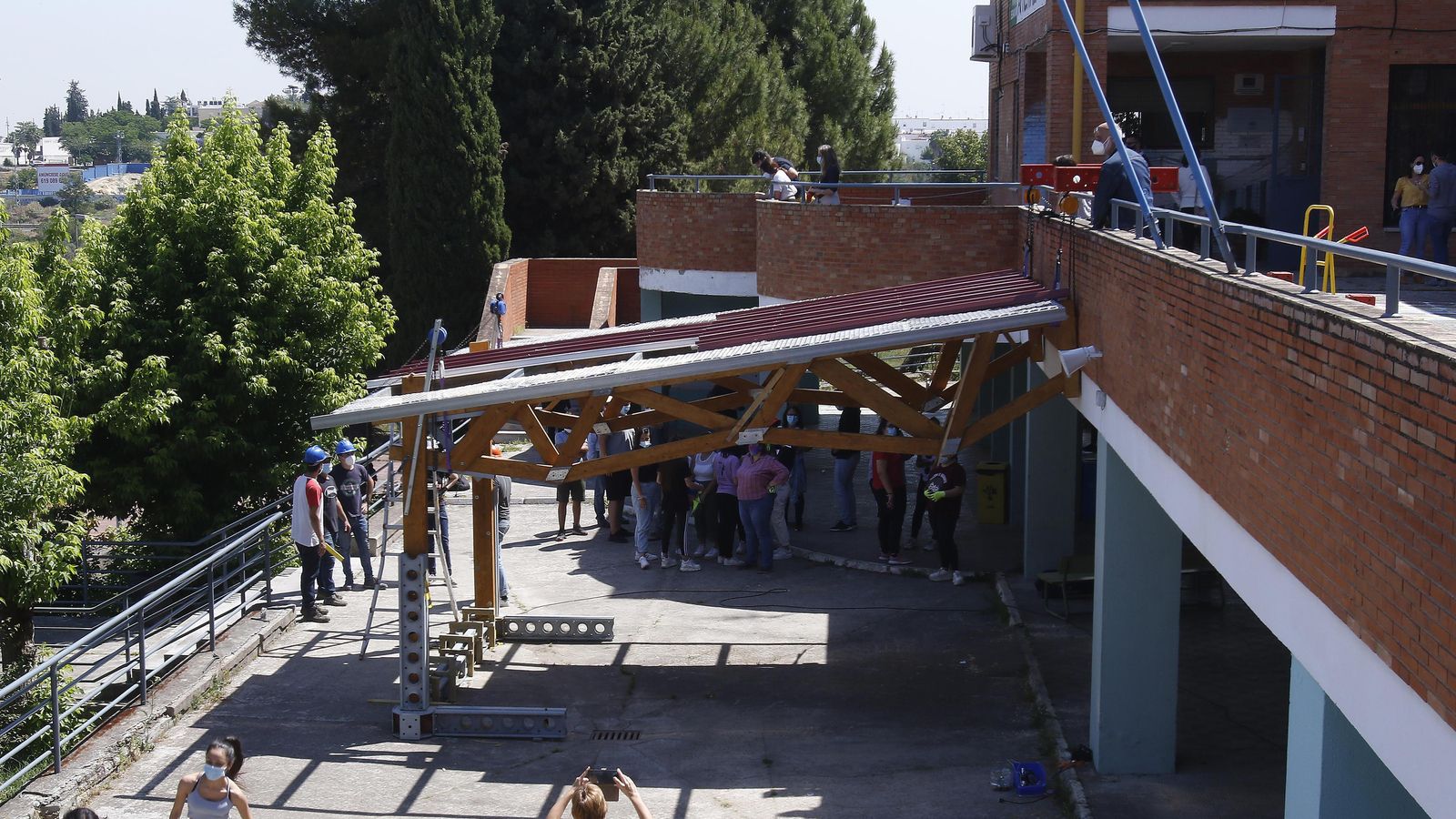 La pérgola colocada da sombra y permite dar clases al aire libre.  La estructura de 24 m2 es de madera y acero reciclados.