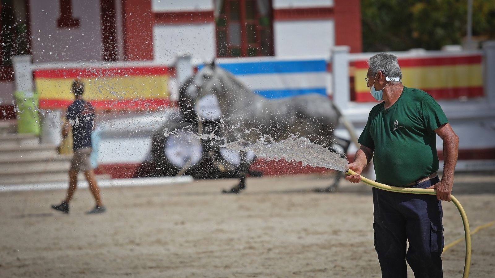 Un operario riega la pista. El calor hizo estragos.