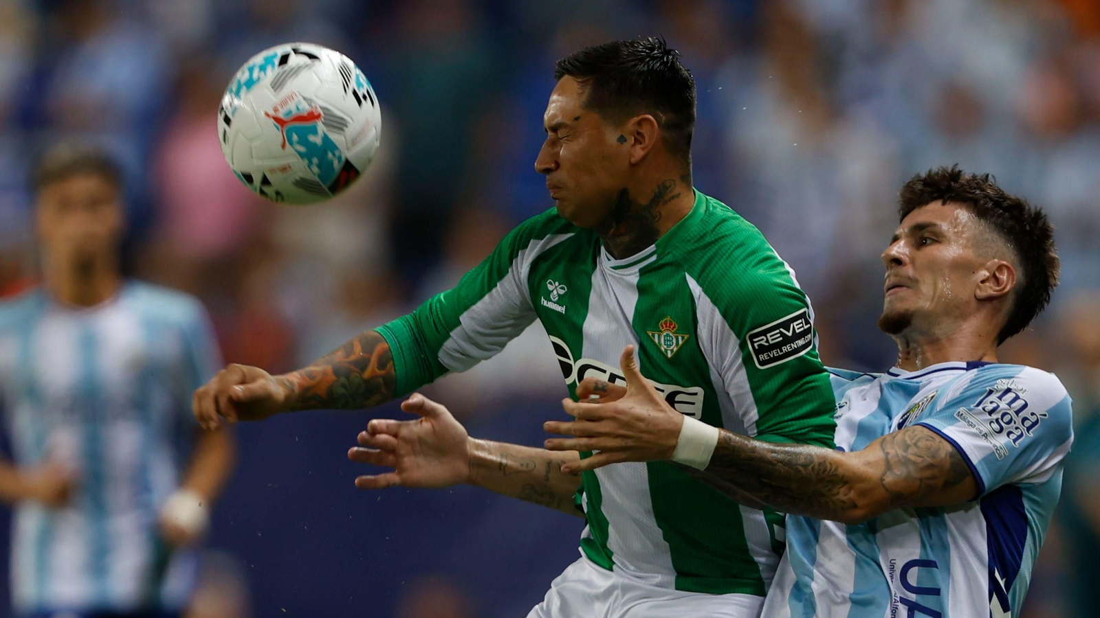 Chimy Ávila golpea de cabeza la pelota ante la presión del malaguista Murillo.