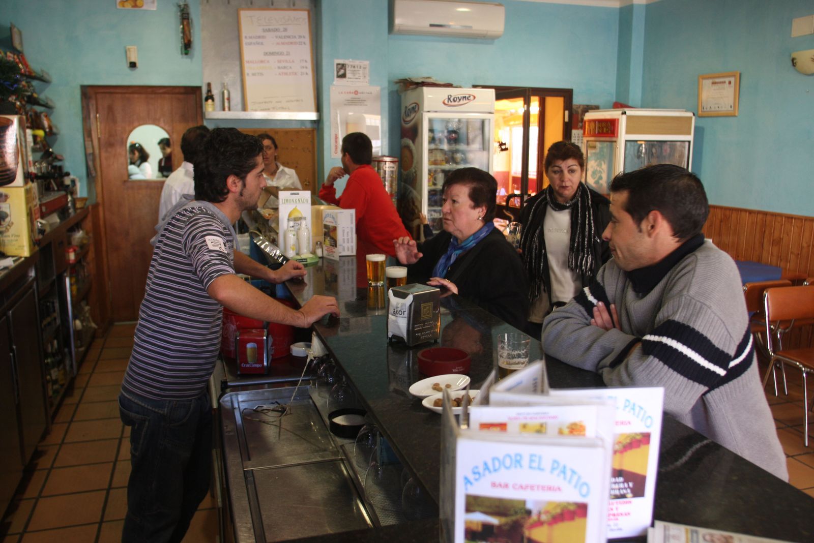 Camareros y clientes en un bar de un pueblo sevillano.