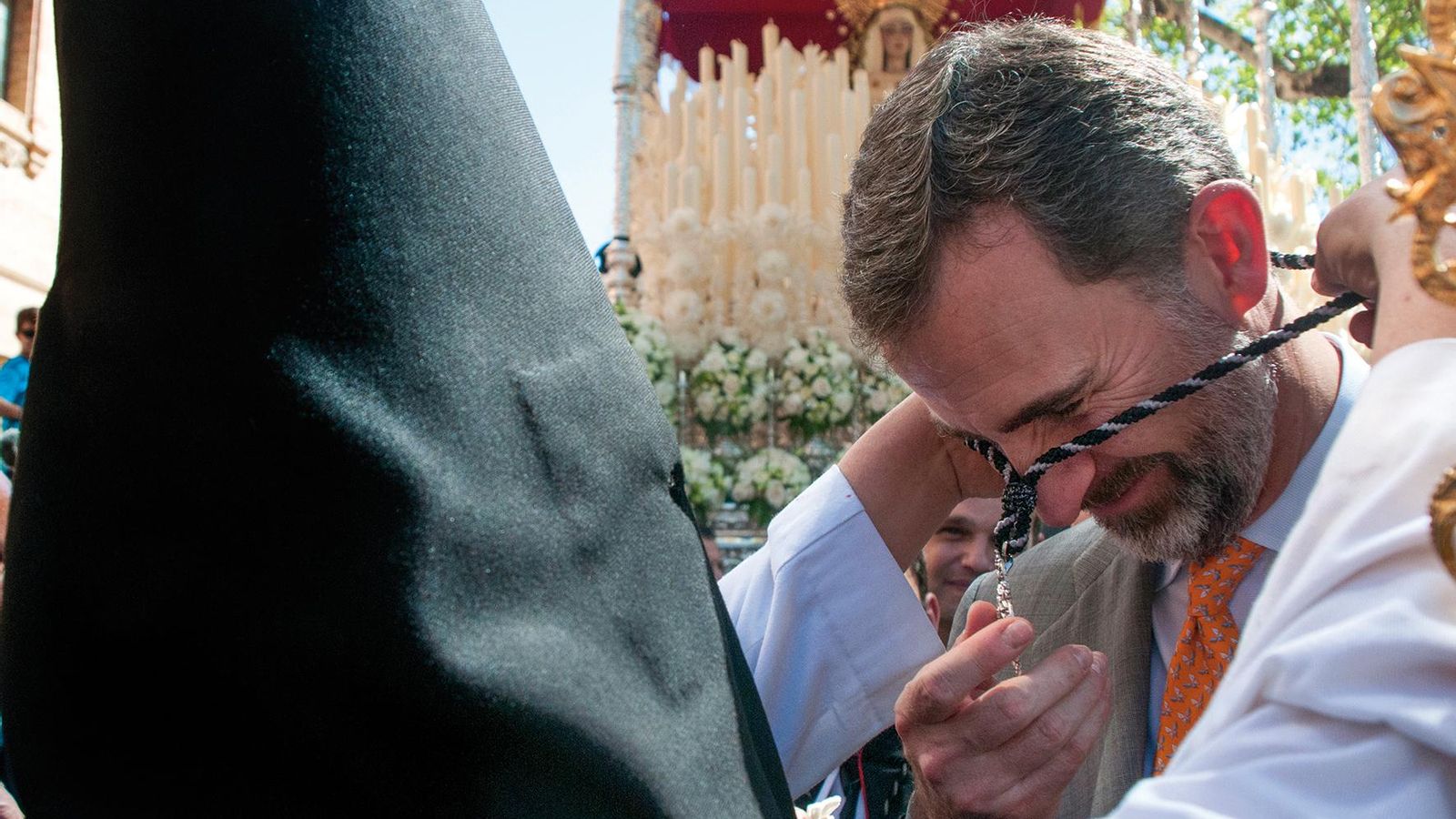 El rey Felipe VI recibe la medalla de la hermandad ante el paso de la Virgen.