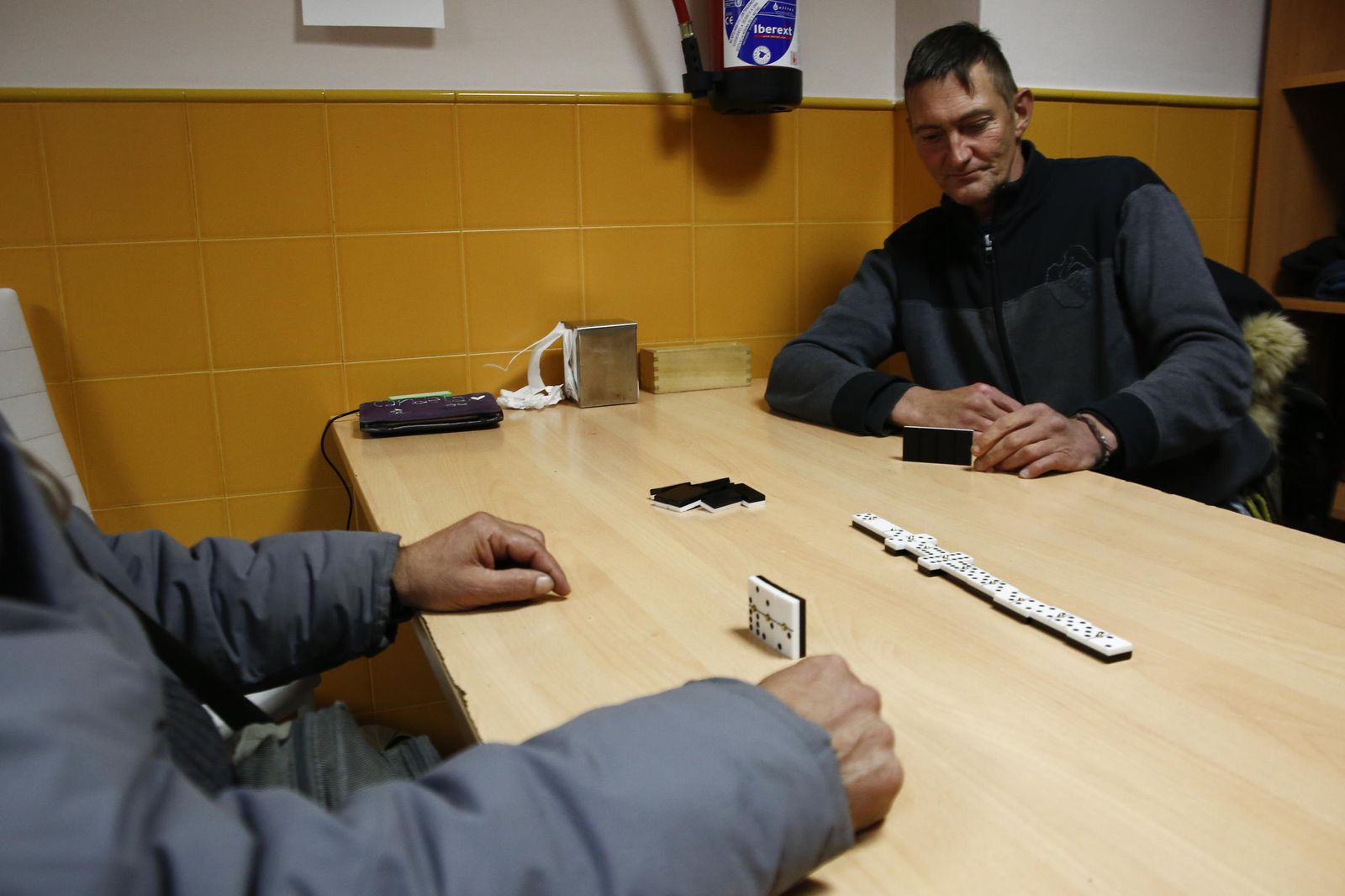 Dos usuarios del centro jugando al dominó.