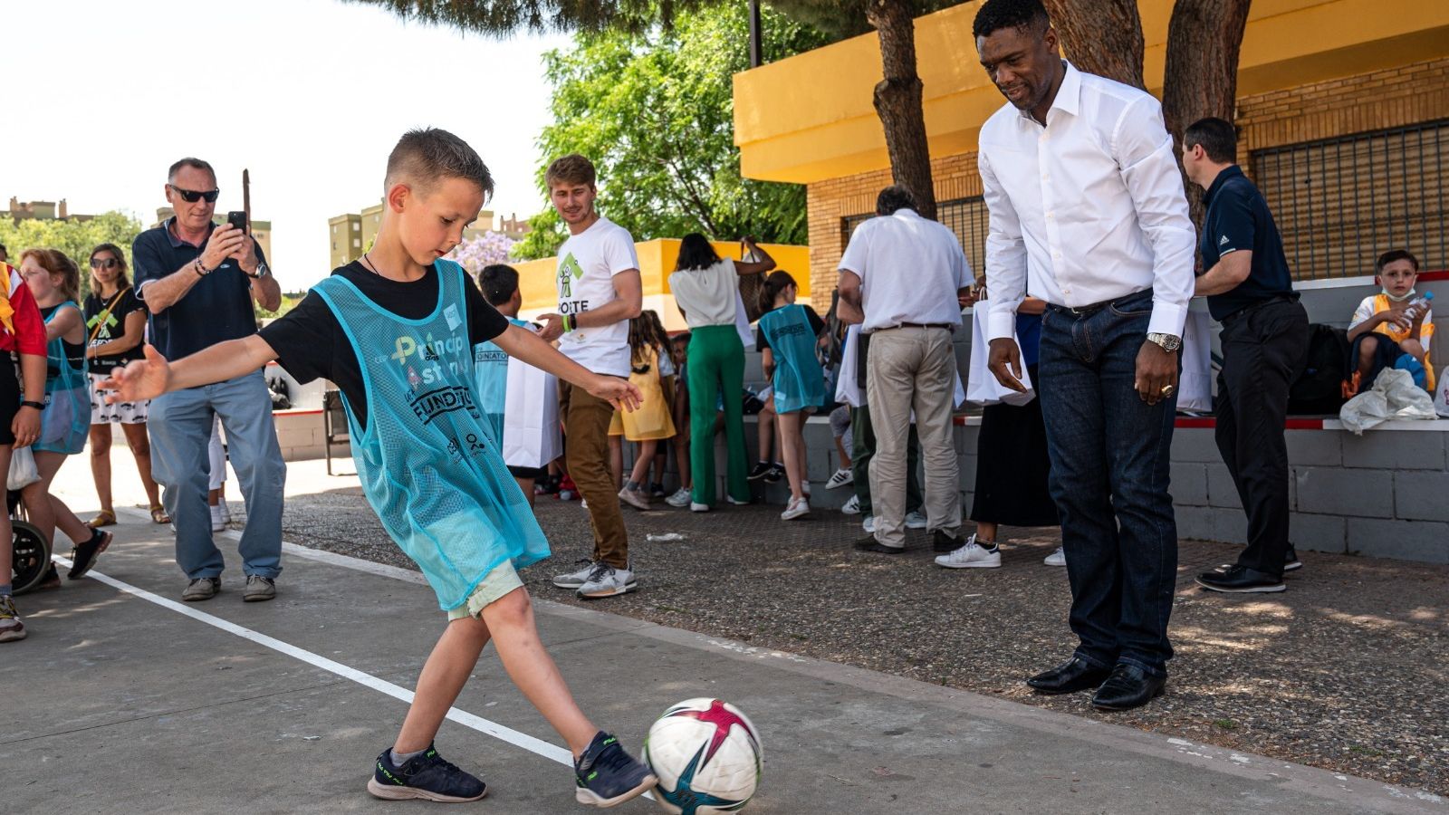 Seedorf juega con un pequeño al balón.