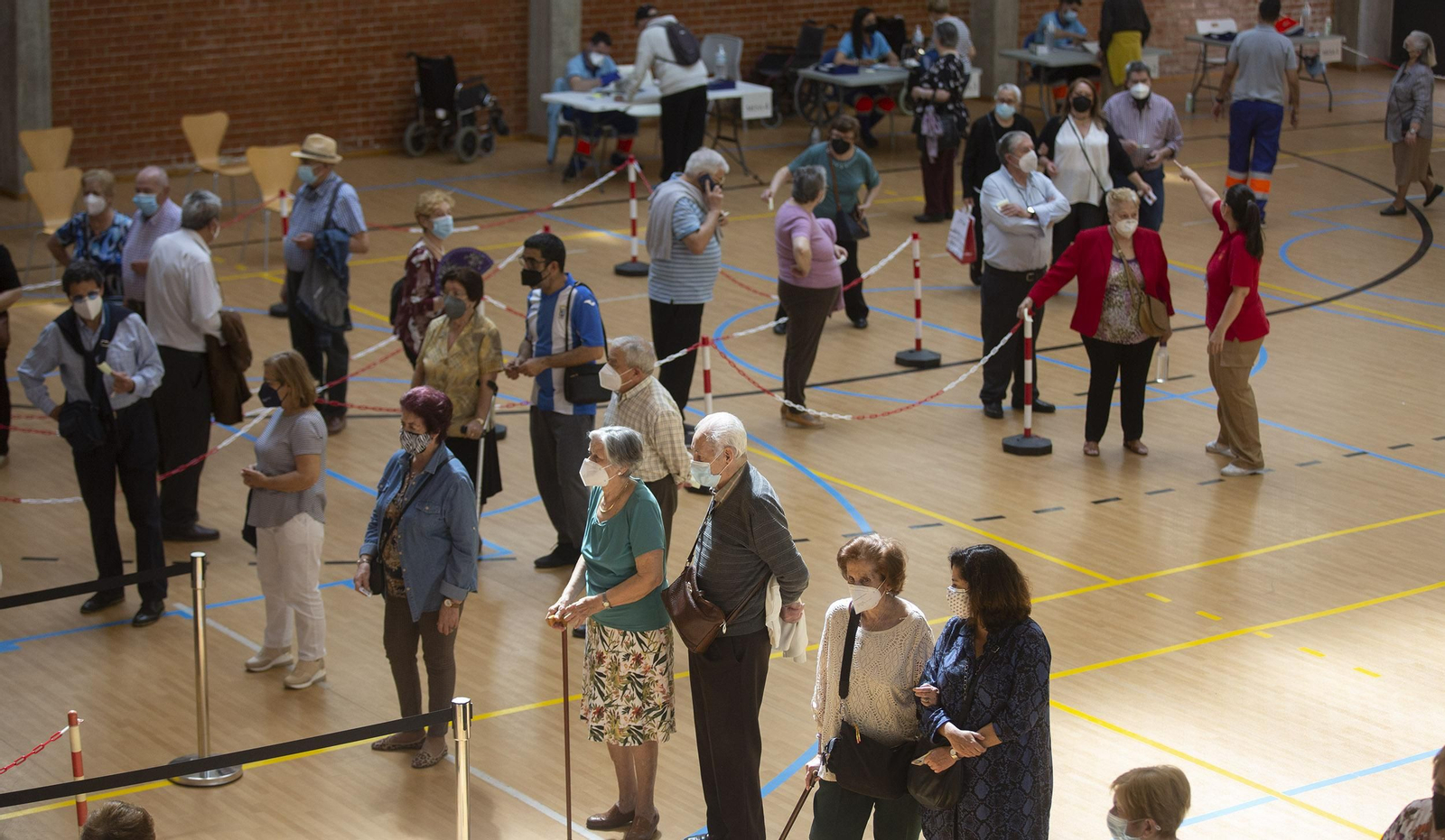 Varias personas esperan su turno para ser vacunados en el campus Ramón y Cajal de la Universidad de Sevilla.