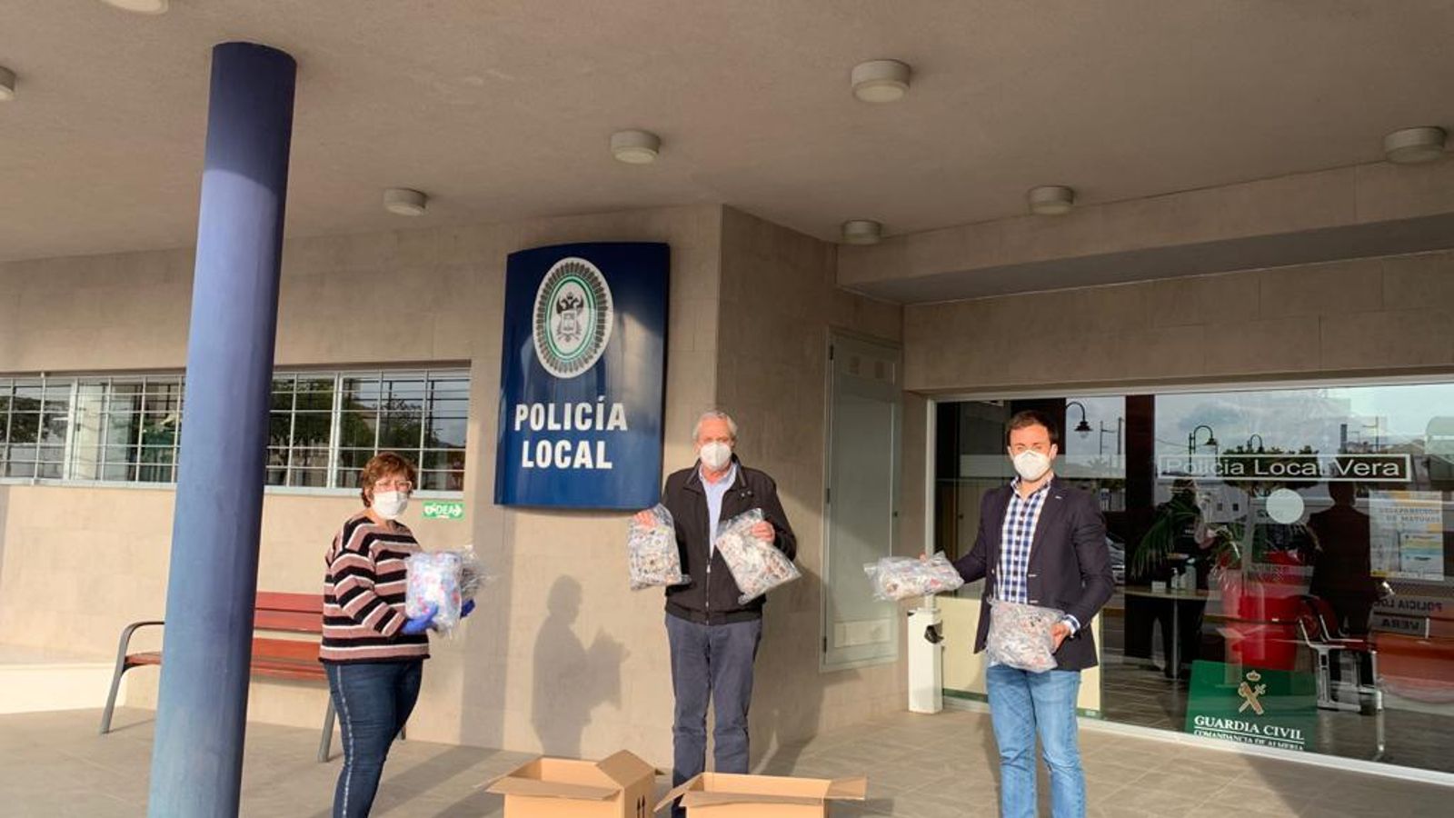 El alcalde recibe las mascarillas de manos de la coordinadora de las costureras.