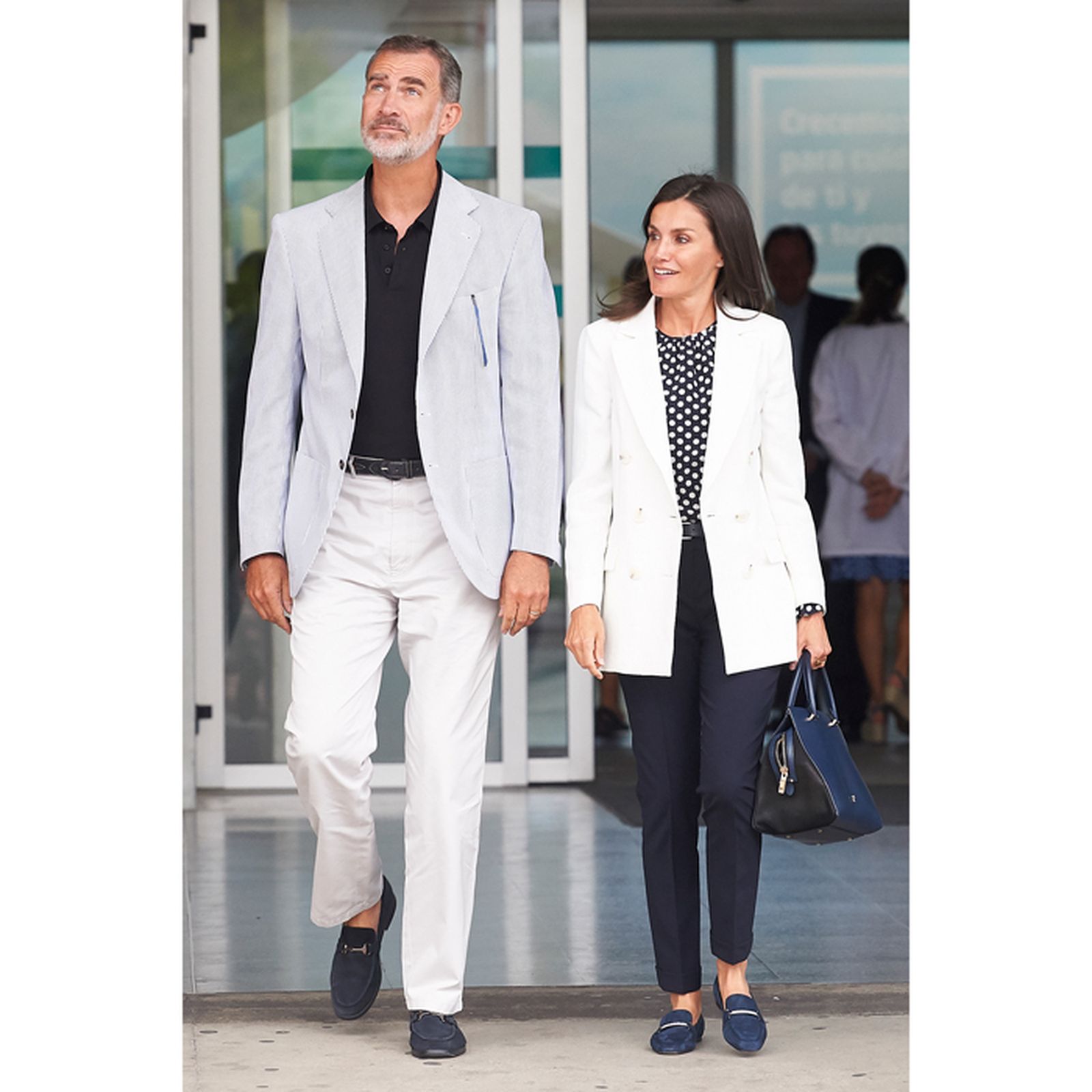 Con mocasines azules, chaqueta sport gris, polo negro y vaqueros blancos, junto a Doña Letizia.