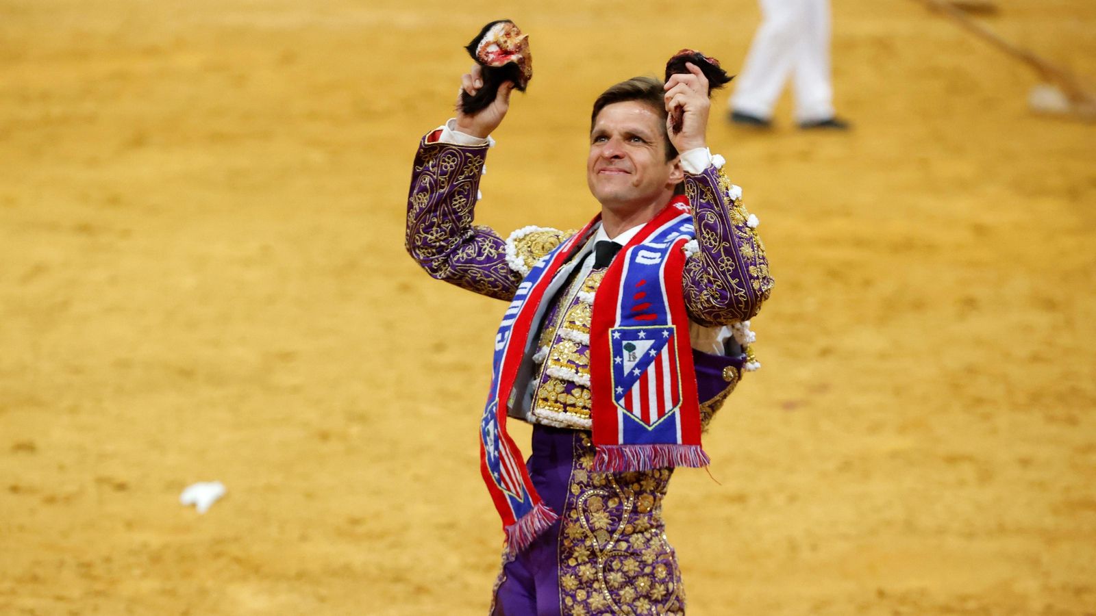 El Juli presume de orejas con una bufanda del Atlético de Madrid colgada al cuello.