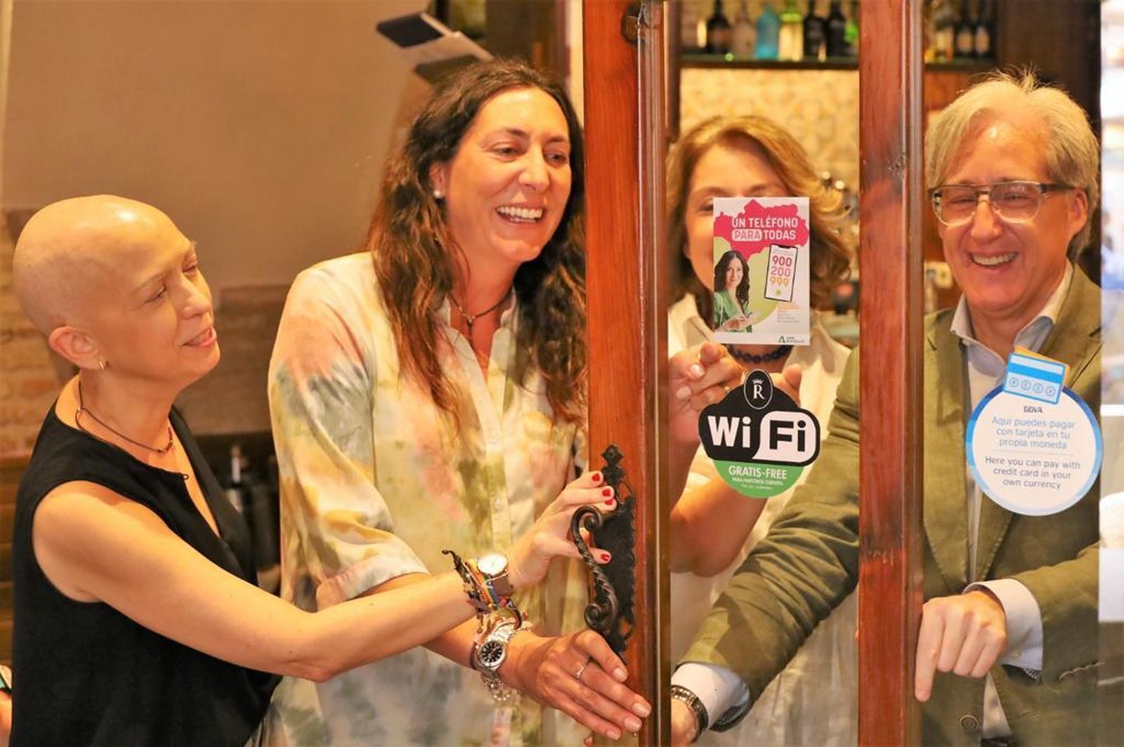 Loles López observa un cartel con la nueva imagen del teléfono andaluz de atención a las mujeres.