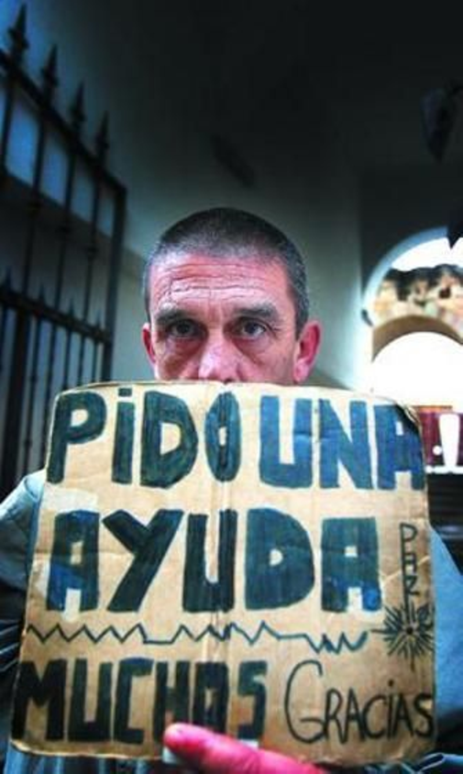 Juan Carlos, ex trabajador de la agencia Efe, exhibe el cartón con el que pide dinero en Jerez.