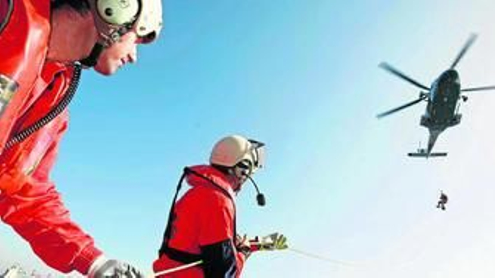José San Isidro y Ángel Tierra agarran la cuerda por la que baja del Helimer 218 el nadador de rescate Ángel Segura.