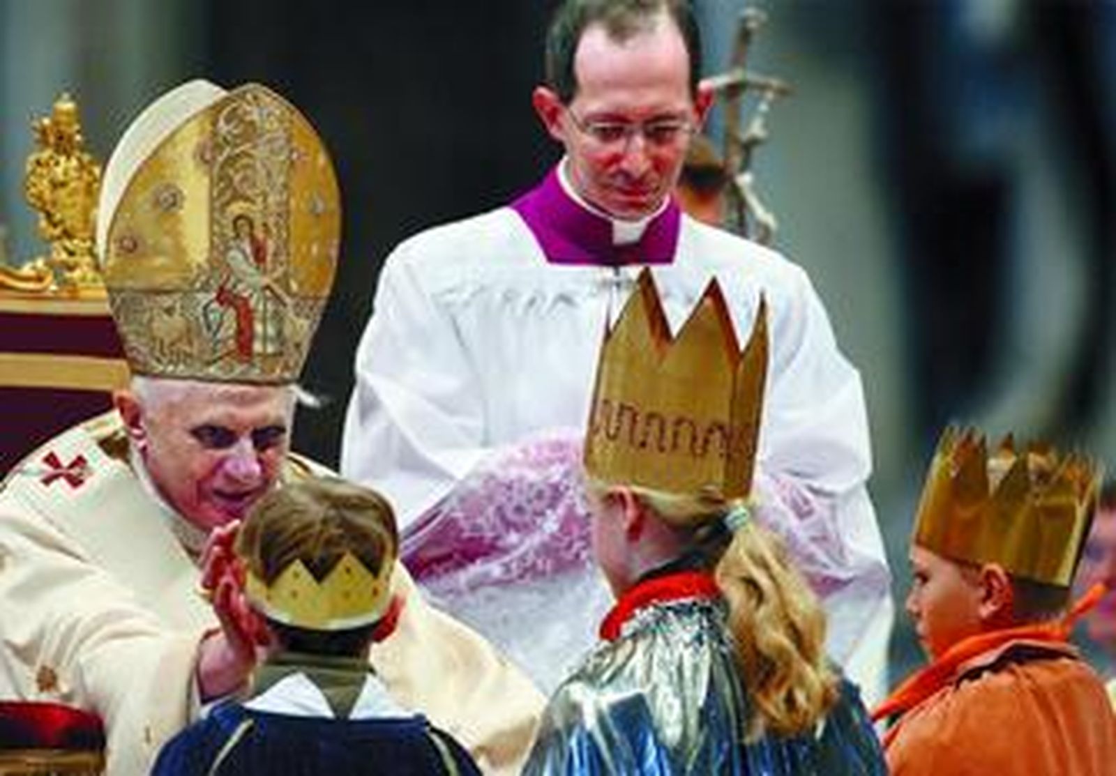 Benedicto XVI saluda a tres niños vestidos de Reyes Magos en la misa de ayer, en San Pedro.