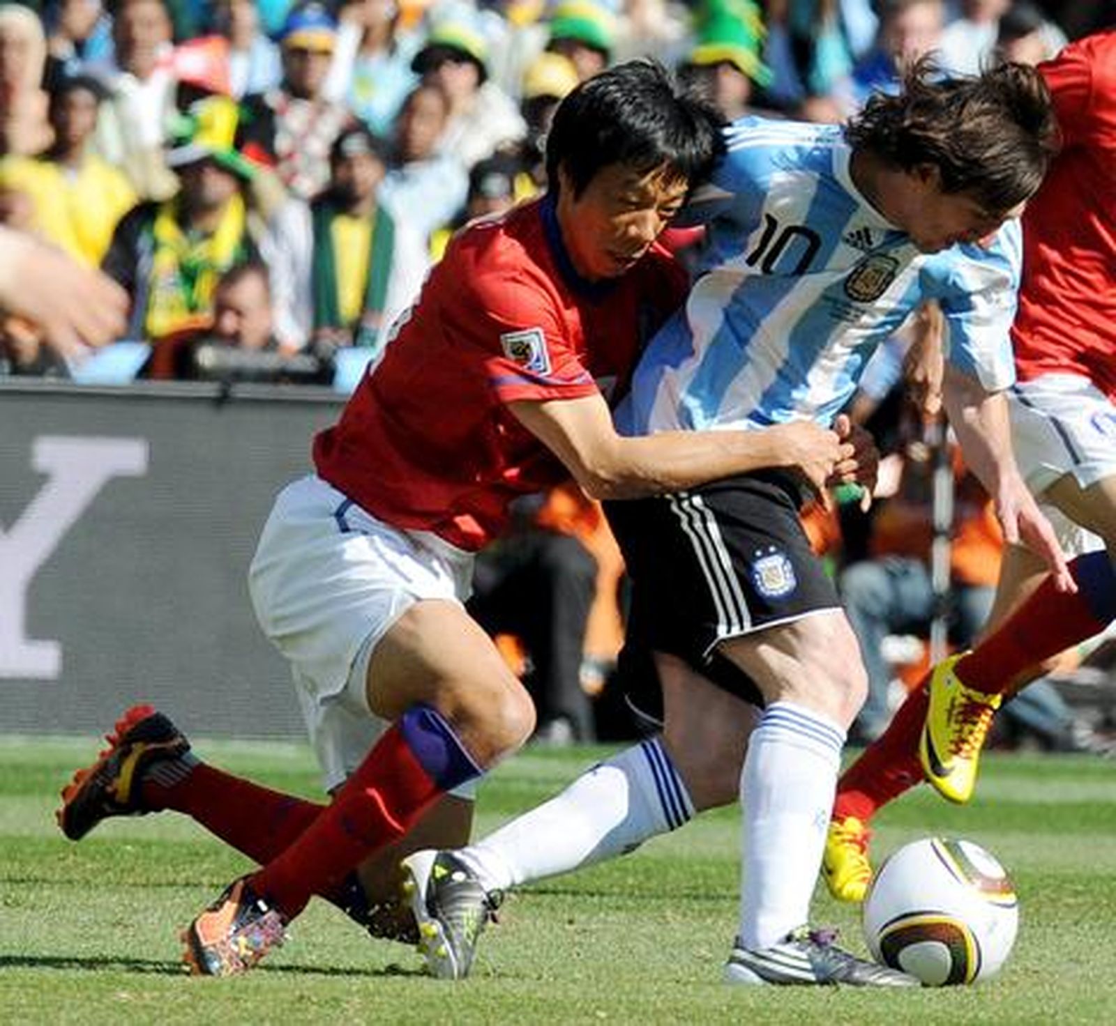 Un defensa trata de parar a Messi agarrándolo. / Reportaje gráfico: EFE, Reuters, AFP