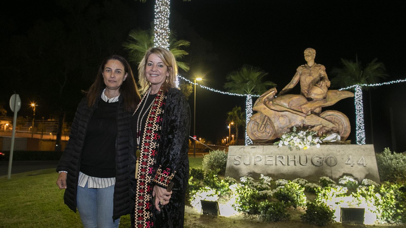 La madre de Hugo Millán, Ana Belén Gracia, y la presidenta del Puerto, Pilar Miranda, junto al monumento de su hijo.