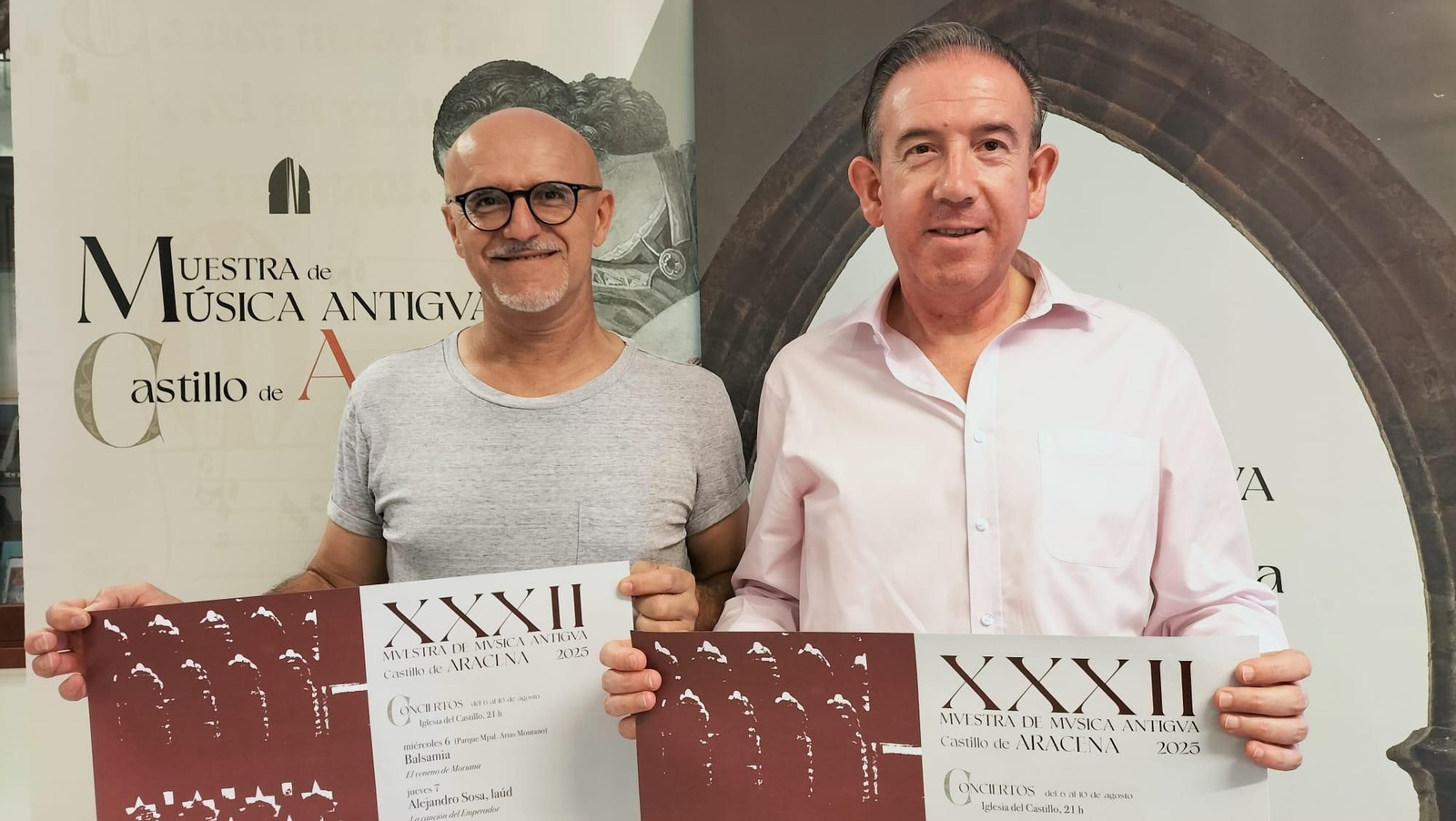 El alcalde de Aracena y el director de la muestra posando con el cartel