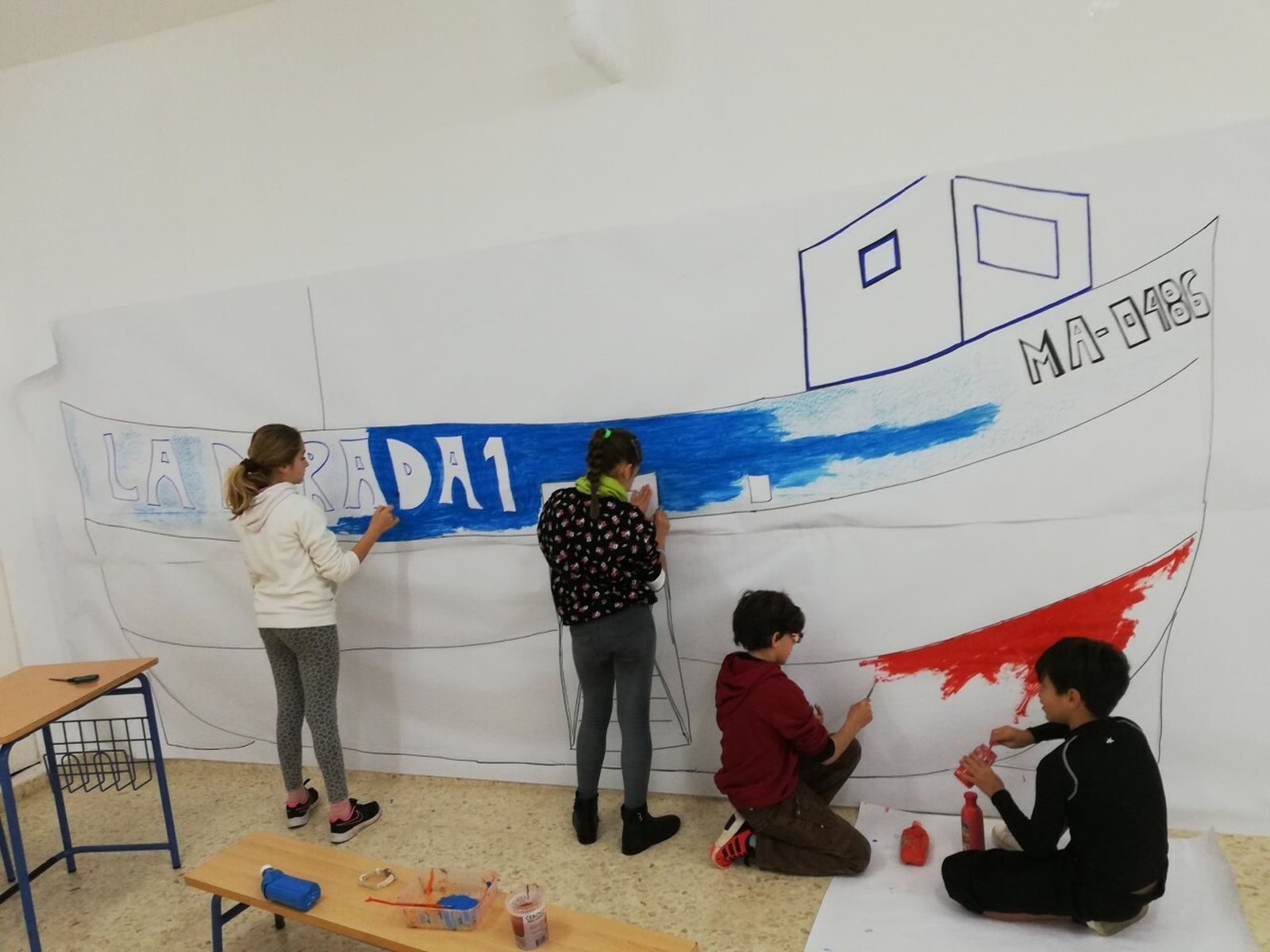 Alumnos del CEIP Nuestra Señora del Carmen pintan el barco de Chanquete.