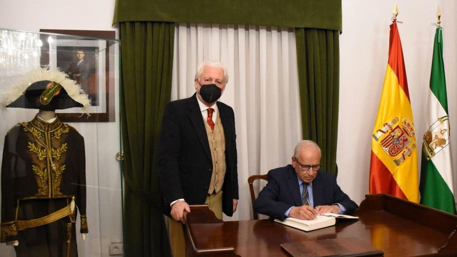 Guerra firma en el libro de honor de la Academia.