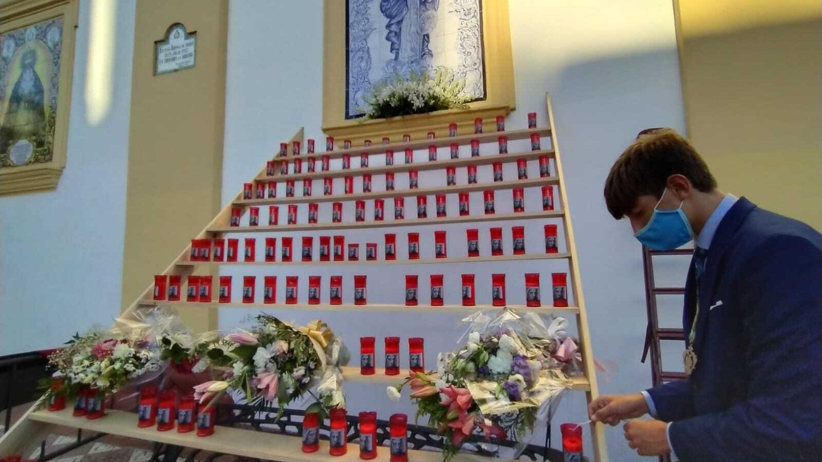 Colocando velas ante el azulejo del templo.