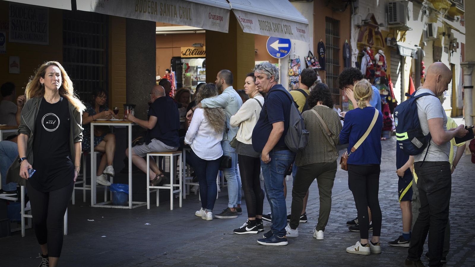 Un grupo de turistas hace cola ante la puerta de una bodega de la calle Mateos Gago.
