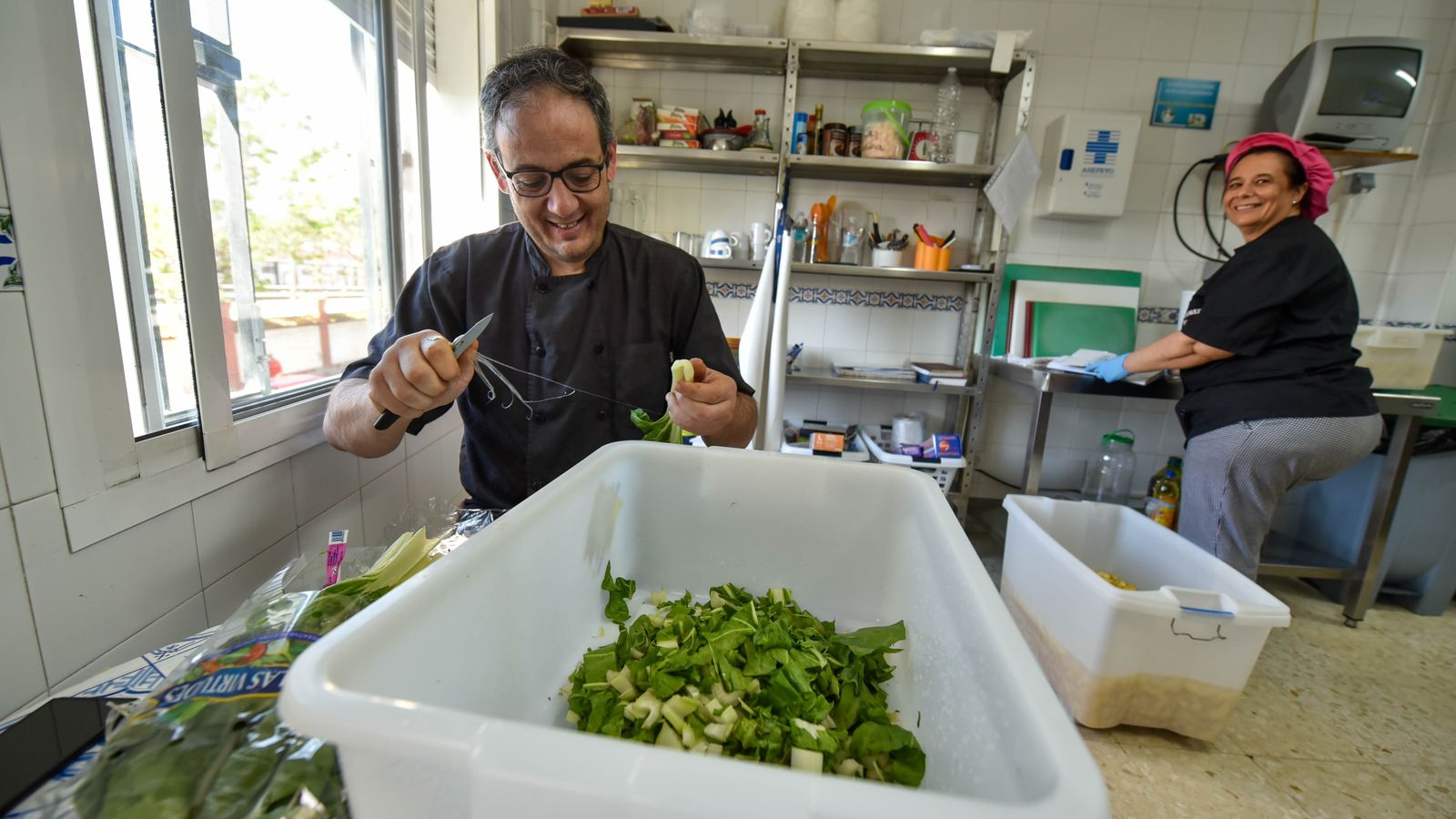Los voluntarios preparan unas acelgas donadas por Mercadona.