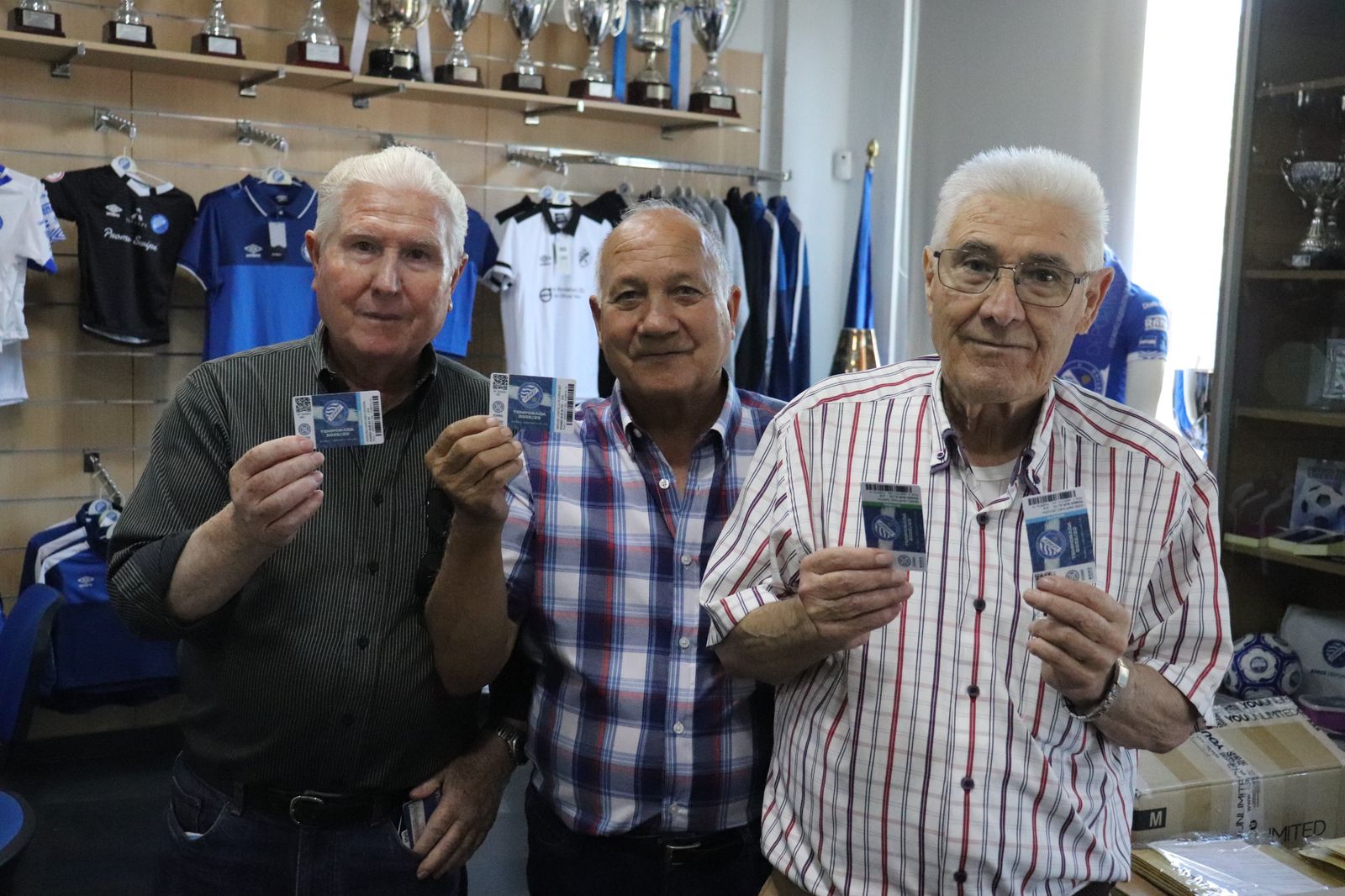 Tres socios del Xerez DFC muestran sus carnés.