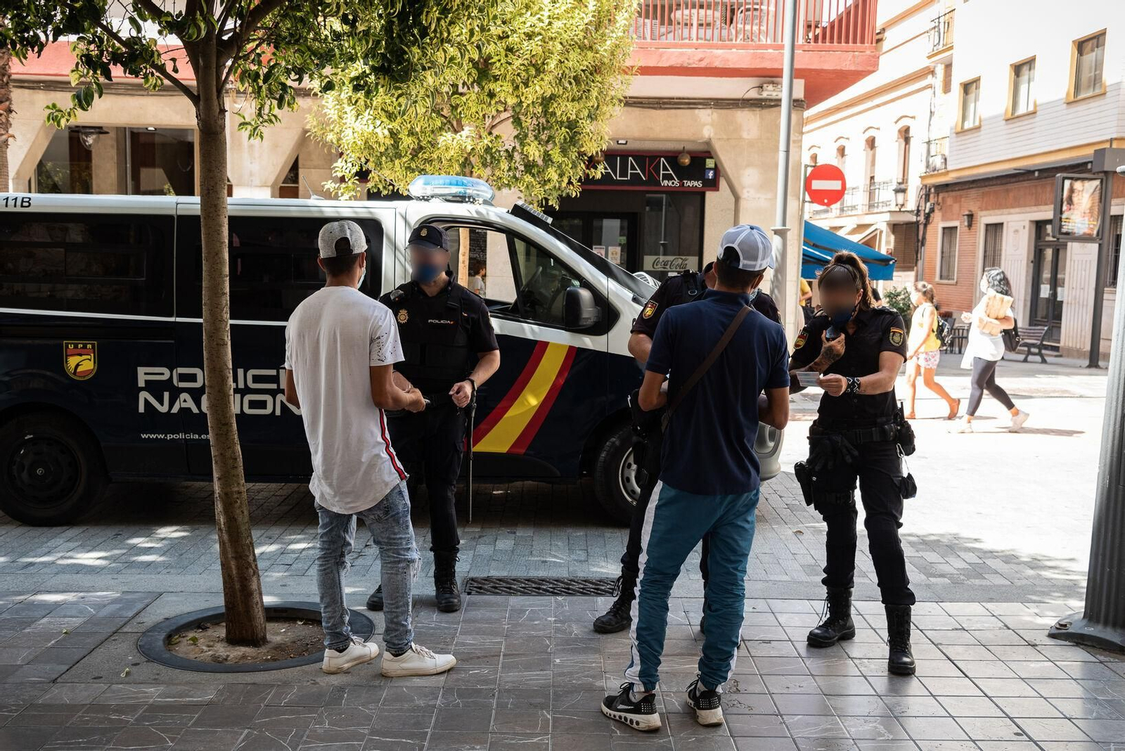 Dos agentes charlan con jóvenes en la Gran Vía el verano pasado.