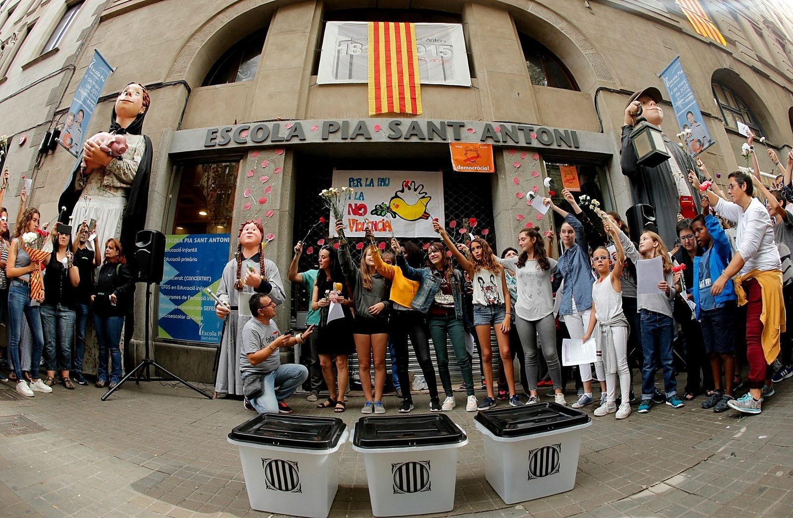 Concentración ante la Escola Pia del barrio de Sant Antoni de Barcelona, junto a unas urnas, durante la jornada de paro de ayer en Cataluña.